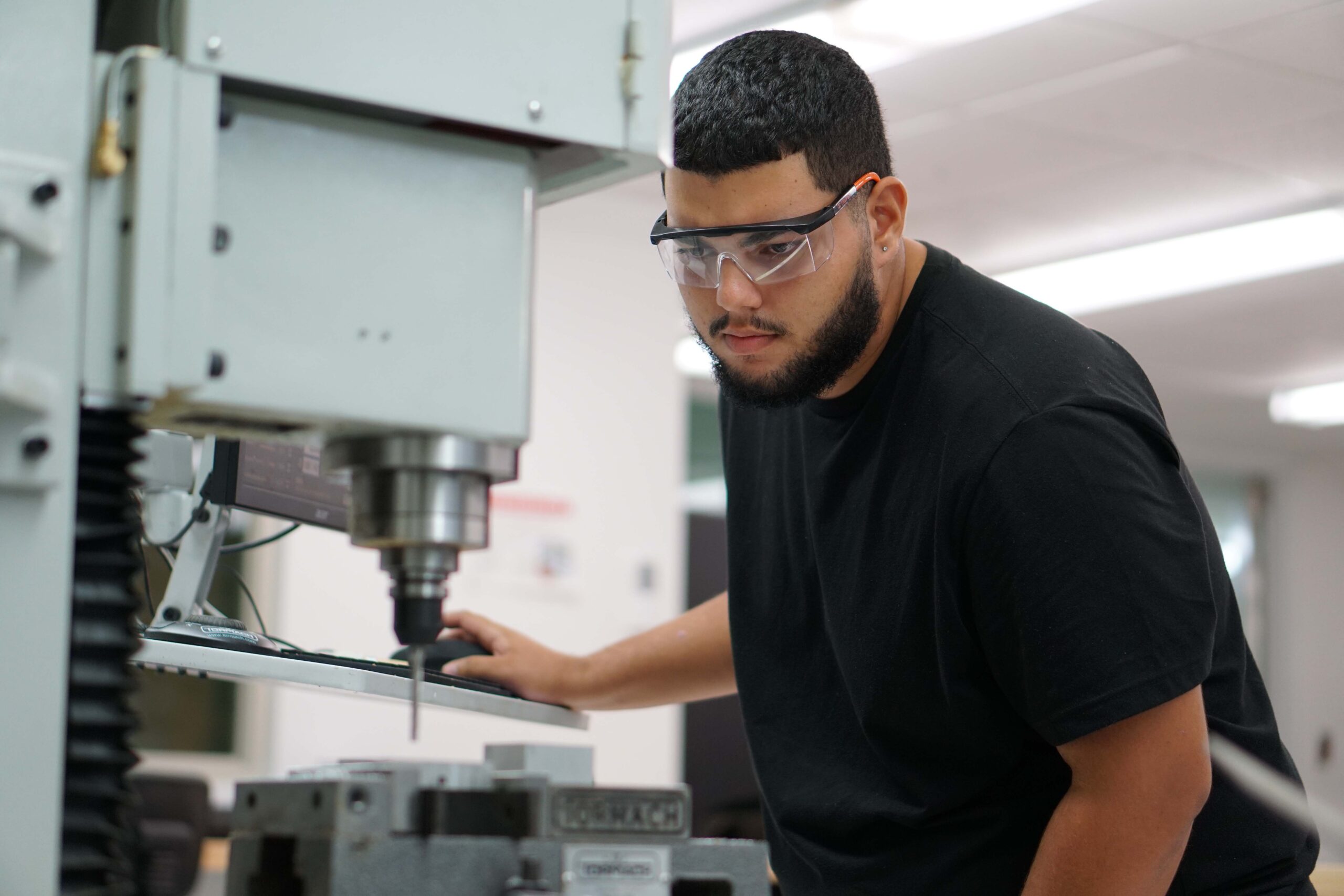 Estudiante realizando un tipo de fabricación con maquinaria computarizada